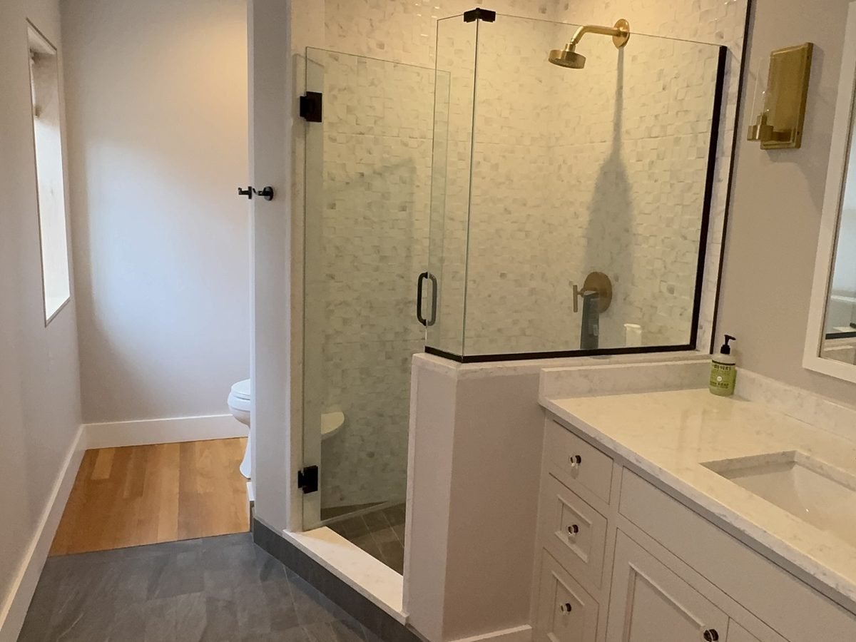 Master bathroom with a glass shower and freshly painted white vanity