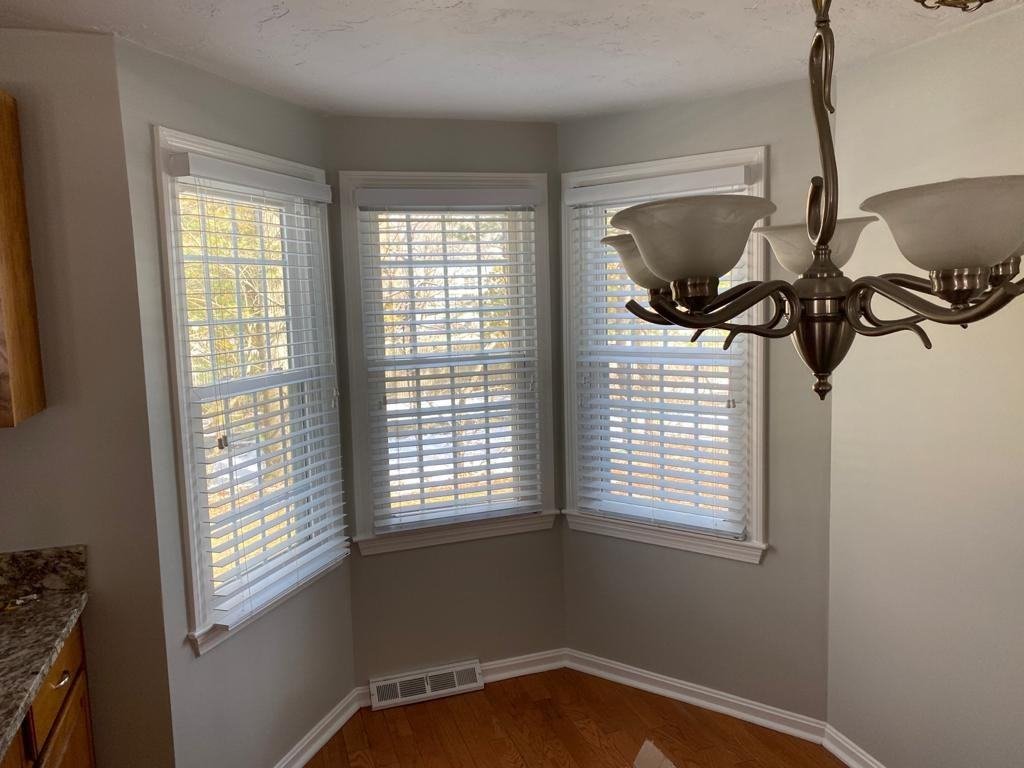 Bay window with plantation shutters, warm gray walls and crisp white trim