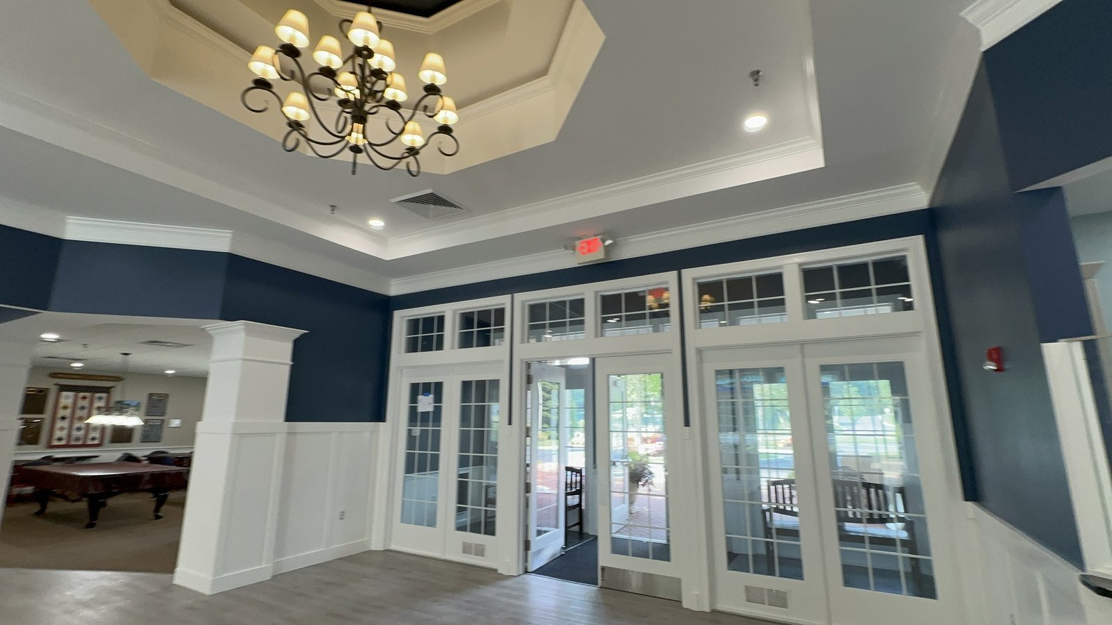 Function room with deep navy walls, white wainscot and freshly painted French doors