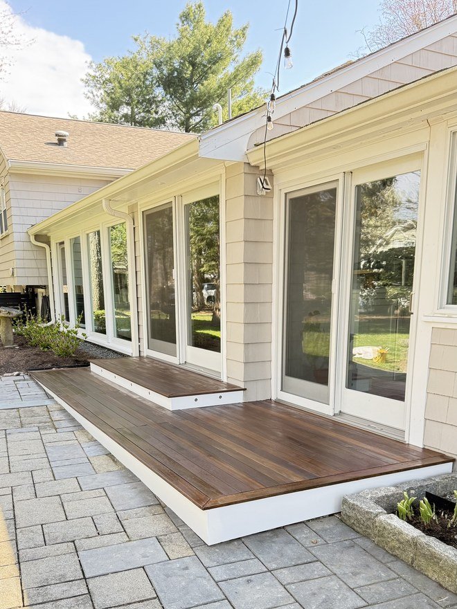 Paver terrace with a stained mahogany landing and freshly painted white trim
